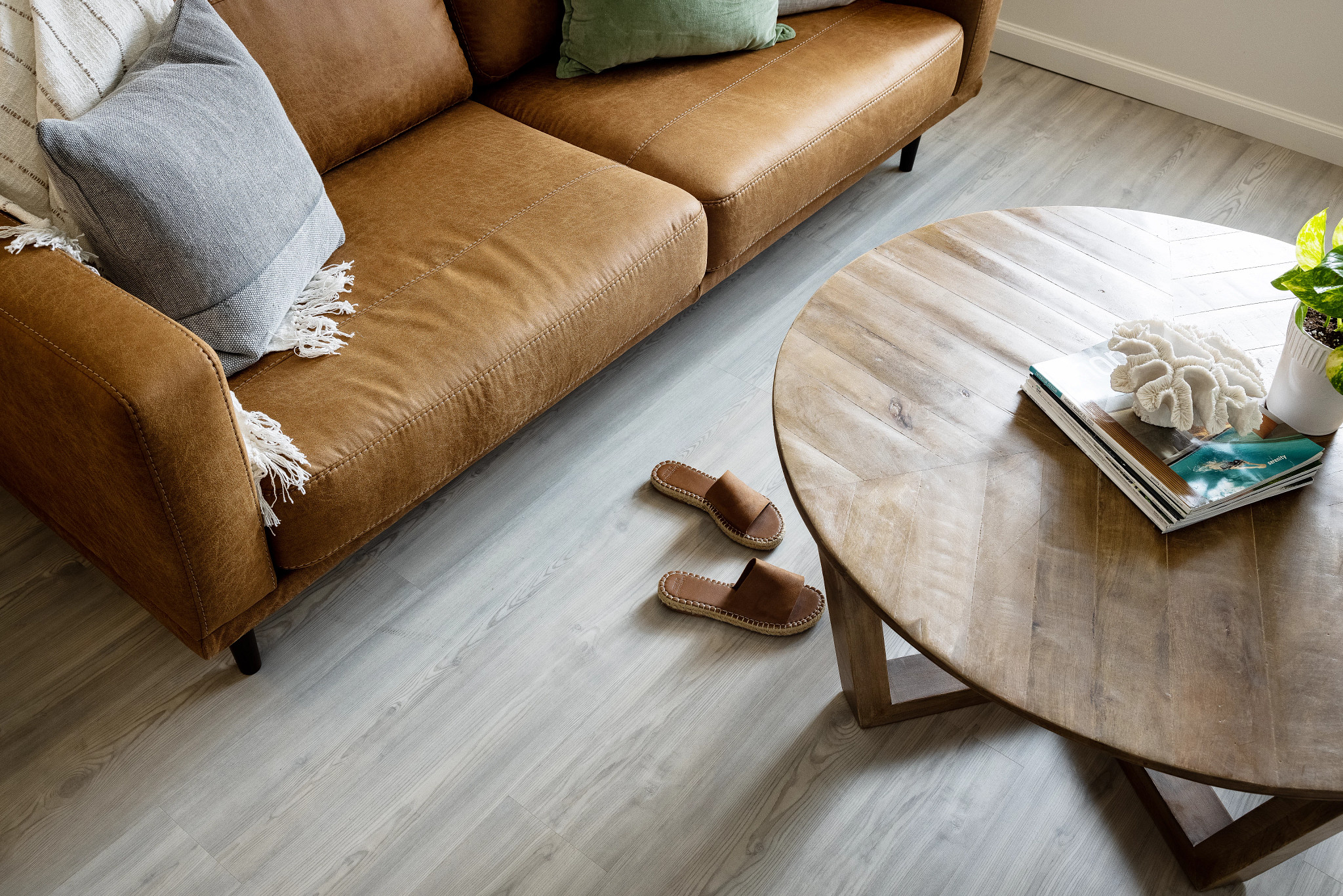 livingroom leather couch round coffee table shoes on floor